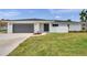 Charming single-story home featuring a gray garage door and a well-manicured lawn at 5125 Palm Aire Dr, Sarasota, FL 34243
