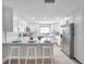 Bright kitchen boasts white cabinetry, stainless steel appliances, quartz countertops and bar stool seating at 5125 Palm Aire Dr, Sarasota, FL 34243