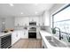 Updated kitchen with stainless steel appliances, quartz countertops, white cabinetry and eat in breakfast bar at 5125 Palm Aire Dr, Sarasota, FL 34243