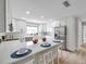Bright kitchen boasts white cabinetry, stainless steel appliances, quartz countertops and bar stool seating at 5125 Palm Aire Dr, Sarasota, FL 34243