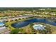 Scenic aerial view of the community featuring a tranquil pond and inviting pool area with lounge chairs at 5358 Shell Mound Cir, Punta Gorda, FL 33982