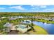 Aerial view of the community pool, clubhouse, and the tranquil lake around single Gathering homes at 5358 Shell Mound Cir, Punta Gorda, FL 33982