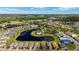 Wide aerial shot featuring the residential community, lake, and a shopping center in the distance at 5358 Shell Mound Cir, Punta Gorda, FL 33982