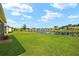 Expansive backyard with lush green grass and a tranquil view of the pond and surrounding houses at 5358 Shell Mound Cir, Punta Gorda, FL 33982