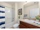 Bright bathroom with a shower-tub combo, stylish sink with a wood cabinet and neutral color palette at 5358 Shell Mound Cir, Punta Gorda, FL 33982
