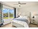 Bedroom with scenic views of the lake with large windows and a ceiling fan at 5358 Shell Mound Cir, Punta Gorda, FL 33982