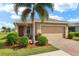 Charming single-story home with a well-manicured lawn, beautiful landscaping, and a brick-paved driveway at 5358 Shell Mound Cir, Punta Gorda, FL 33982