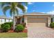 Charming single-story home with a well-manicured lawn, beautiful landscaping, and a brick-paved driveway at 5358 Shell Mound Cir, Punta Gorda, FL 33982