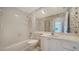 Well-lit bathroom with a shower-tub combo, decorative wallpaper, and a vanity at 5566 Avellino Pl, Sarasota, FL 34238