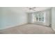 Carpeted bedroom with a bright window dressed with white curtains at 5566 Avellino Pl, Sarasota, FL 34238