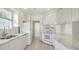 Bright kitchen featuring white cabinetry, tile flooring, and stainless steel appliances at 5566 Avellino Pl, Sarasota, FL 34238