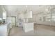 Well-lit kitchen with white cabinetry, white appliances, tile flooring and breakfast bar seating at 5566 Avellino Pl, Sarasota, FL 34238