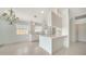 Open-concept kitchen with white cabinets, tile floors, breakfast bar, and chandelier lighting at 5566 Avellino Pl, Sarasota, FL 34238