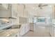Modern kitchen with white cabinetry, tile floors and stainless steel appliances that flows to the living area at 5566 Avellino Pl, Sarasota, FL 34238