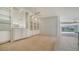 Living room featuring wall-to-wall carpet, built-in shelves and large windows for natural light at 5566 Avellino Pl, Sarasota, FL 34238