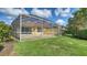 A screened-in patio overlooking the lawn, with a view of a palm tree in the backyard at 5566 Avellino Pl, Sarasota, FL 34238