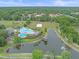 An aerial view showcases the community pool, clubhouse, and a serene lake with a fountain feature at 5618 Sheer Bliss Loop, Land O Lakes, FL 34639