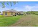 Expansive backyard featuring a covered patio, verdant lawn, and a glimpse of the home's facade at 5618 Sheer Bliss Loop, Land O Lakes, FL 34639