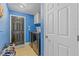 Well-equipped laundry room with black washer/dryer, cabinet, storage and access to the garage and home at 5618 Sheer Bliss Loop, Land O Lakes, FL 34639