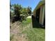 A view of the backyard with grass, tropical plants, and a screened-in porch at 6121 35Th E Ct, Bradenton, FL 34203