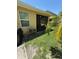 A view of the backyard with grass, tropical plants, and a screened-in porch at 6121 35Th E Ct, Bradenton, FL 34203