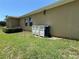 Backyard featuring lawn, home exterior, and garbage bins at 6121 35Th E Ct, Bradenton, FL 34203