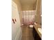 The bathroom features a flower shower curtain, toilet and vanity with a decorative mirror at 6121 35Th E Ct, Bradenton, FL 34203