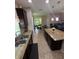 Open kitchen with granite island, stainless steel appliances, and connected dining and living spaces at 6121 35Th E Ct, Bradenton, FL 34203