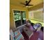 Comfortable screened lanai with seating area, ceiling fan, and views of the lush tropical backyard at 6121 35Th E Ct, Bradenton, FL 34203