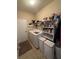 Practical laundry room equipped with a washer, dryer, shelving, and storage for efficient home management at 6121 35Th E Ct, Bradenton, FL 34203