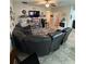 Spacious living room with a sectional sofa, decorative shelves, and views into the entry and kitchen at 6121 35Th E Ct, Bradenton, FL 34203