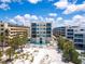 Aerial view of the Crescent Beach Residences and the surrounding area with palm trees, beach, and pool at 6512 Midnight Pass Rd # 301, Sarasota, FL 34242