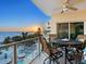 Balcony with outdoor seating, table, and sunset view of the beach at 6512 Midnight Pass Rd # 301, Sarasota, FL 34242