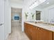 Bathroom featuring a double sink vanity with granite countertops, tub, and tile floors at 6512 Midnight Pass Rd # 301, Sarasota, FL 34242