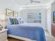 Comfortable bedroom features a bright blue quilt, ceiling fan and plantation shutters at 6512 Midnight Pass Rd # 301, Sarasota, FL 34242