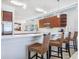 Stylish kitchen with white countertops, wood cabinets, and rattan counter seating at 6512 Midnight Pass Rd # 301, Sarasota, FL 34242
