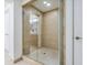 Shower featuring a glass door, tan tile surround, and tiled floors at 6512 Midnight Pass Rd # 301, Sarasota, FL 34242