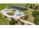Sprawling property with main house, long garage, RV, and pond, surrounded by mature trees and grassy areas at 7160 Myakka Valley Trl, Sarasota, FL 34241