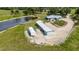 Aerial shot showcases a house near a pond with a RV and long garage in a green landscape at 7160 Myakka Valley Trl, Sarasota, FL 34241
