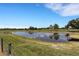 Scenic view of a peaceful pond with wooden docks, surrounded by lush green pastures and mature trees at 7160 Myakka Valley Trl, Sarasota, FL 34241