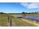 Scenic view of a pond with a wooden dock and surrounding grassy landscape on a sunny day at 7160 Myakka Valley Trl, Sarasota, FL 34241