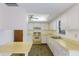 Bright kitchen featuring white cabinets and yellow countertops, showcasing the house’s interior design at 7803 2Nd W Ave, Bradenton, FL 34209