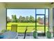 A screened in lanai offers views of the large, green backyard with mature landscaping and trees at 8077 Sandstar Way, Sarasota, FL 34240