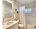 Clean bathroom with a shower-tub combo, white vanity, and neutral wall color at 8077 Sandstar Way, Sarasota, FL 34240