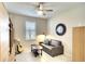 Stylish bonus room with a sofa, guitar, and a ceiling fan at 8077 Sandstar Way, Sarasota, FL 34240