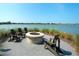 Community firepit with chairs next to the lake provides a cozy outdoor gathering spot at 8077 Sandstar Way, Sarasota, FL 34240