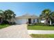 Beautiful single-story home with paver driveway, two-car garage, and lush tropical landscaping at 8077 Sandstar Way, Sarasota, FL 34240