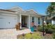 Close-up view of the front porch featuring a chair, potted plants, and decorative landscaping at 8077 Sandstar Way, Sarasota, FL 34240