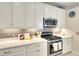 Well-equipped kitchen featuring a gas range, modern appliances, quartz countertops and gray subway tile at 8077 Sandstar Way, Sarasota, FL 34240