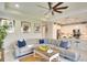 Open concept living room with stylish sofa, tile floors, modern art, and connection to the kitchen at 8077 Sandstar Way, Sarasota, FL 34240
